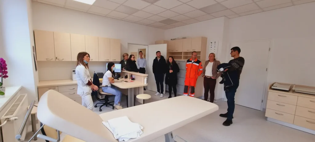 Skupina ljudi z zdravnico, medicinsko sestro in reševalcem v novi otroški ambulanti.
