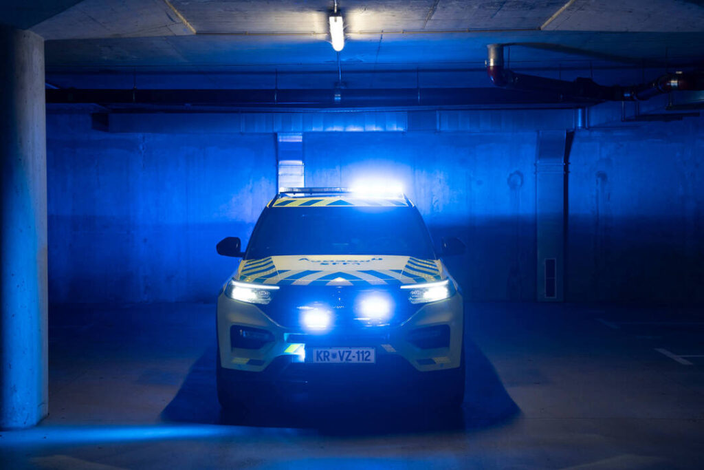 vozilo urgentnega zdravnika z modrimi lučmi, parkirano v garaži